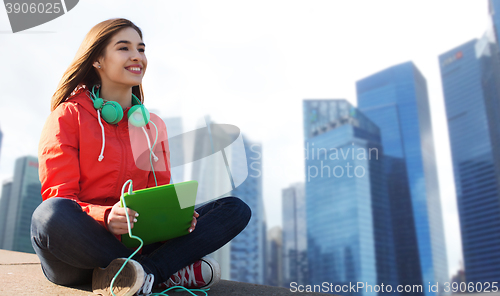 Image of happy young woman with tablet pc and headphones