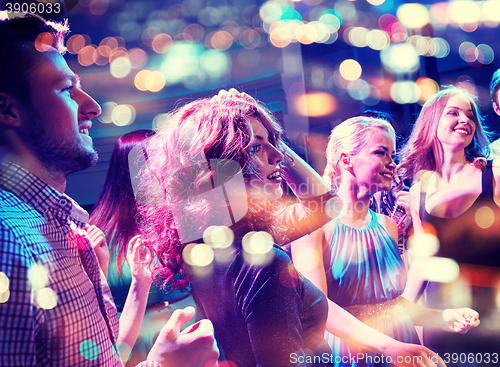 Image of smiling friends dancing in club