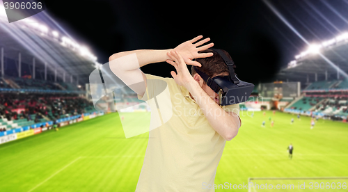 Image of man in virtual reality headset over football field