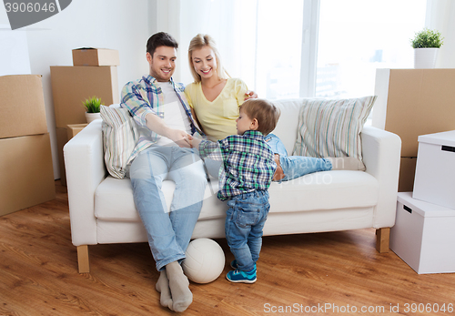 Image of happy family moving to new home and playing ball