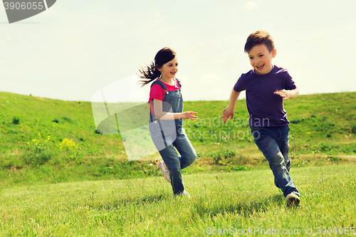 Image of happy little boy and girl running outdoors