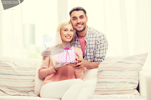 Image of happy man giving woman gift box at home
