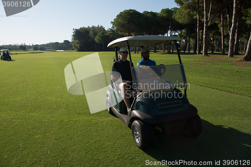 Image of golf players driving cart at course