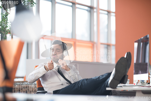 Image of relaxed young business man at office