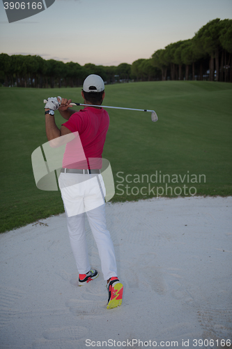 Image of golfer hitting a sand bunker shot on sunset