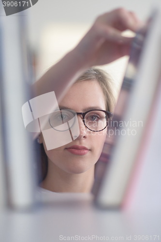 Image of portrait of famale student selecting book to read in library