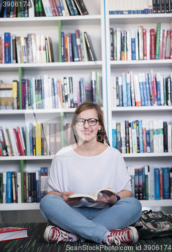 Image of famale student reading book in library