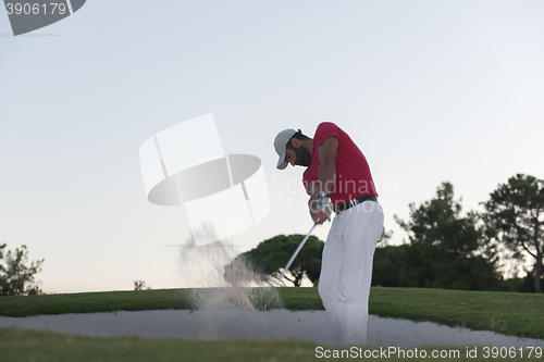 Image of golfer hitting a sand bunker shot on sunset