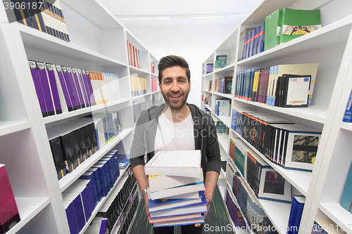 Image of Student holding lot of books in school library