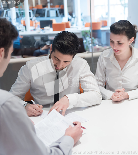 Image of young couple signing contract documents on partners back