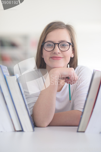 Image of portrait of famale student selecting book to read in library