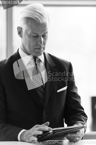 Image of senior business man working on tablet computer
