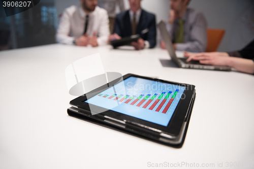 Image of close up of touchpad with analytics documents at business meetin