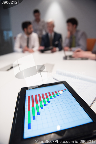 Image of close up of touchpad with analytics documents at business meetin