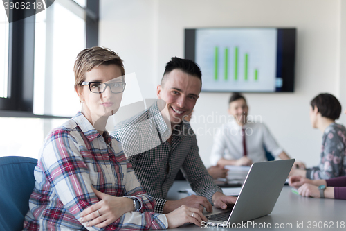 Image of young business couple working on laptop, businesspeople group on