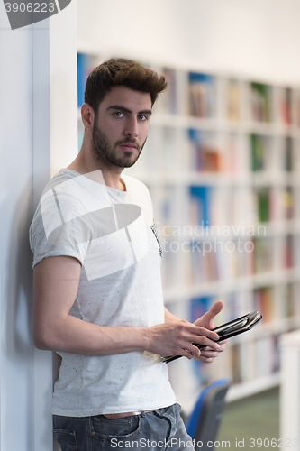 Image of student in school library using tablet for research