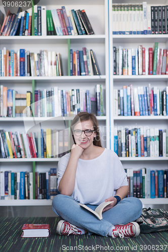 Image of famale student reading book in library