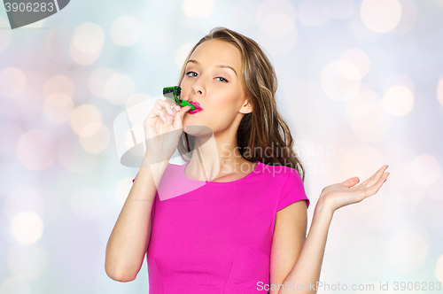 Image of happy young woman or teen girl with party horn