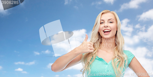 Image of happy woman or teenage girl showing thumbs up