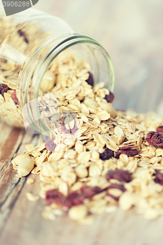 Image of close up of jar with granola or muesli on table