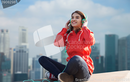 Image of happy young woman in headphones listening to music