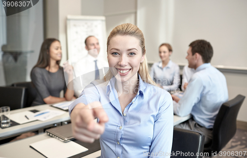 Image of group of smiling businesspeople meeting in office