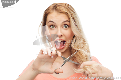 Image of woman with scissors cutting ends of her hair