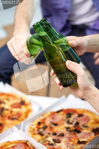 Image of close up of male hands with beer and pizza at home
