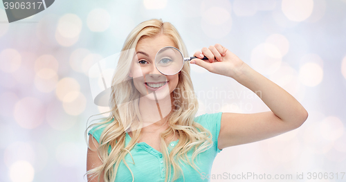 Image of happy young woman with magnifying glass