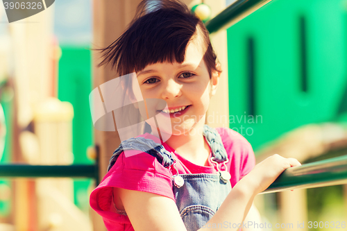 Image of happy little girl climbing on children playground