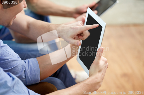 Image of close up of happy friends with tablet pc at home