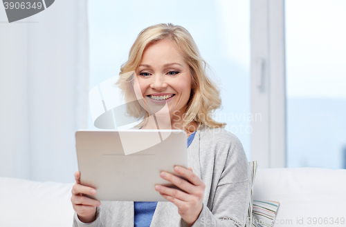 Image of happy middle aged woman with tablet pc at home