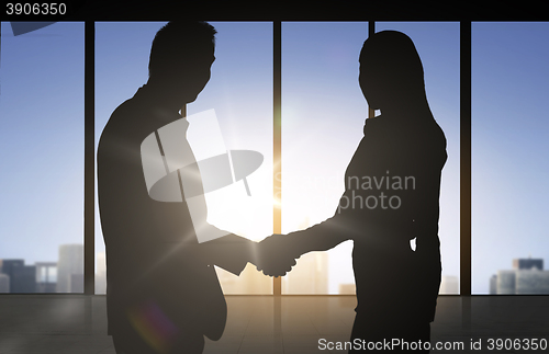 Image of business partners silhouettes shaking hands