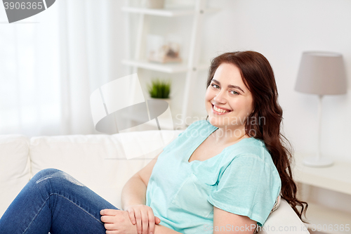 Image of happy young plus size woman at home