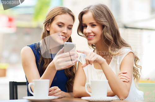 Image of young women with smartphone and coffee at cafe