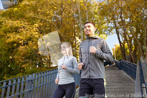 Image of happy couple running downstairs in city