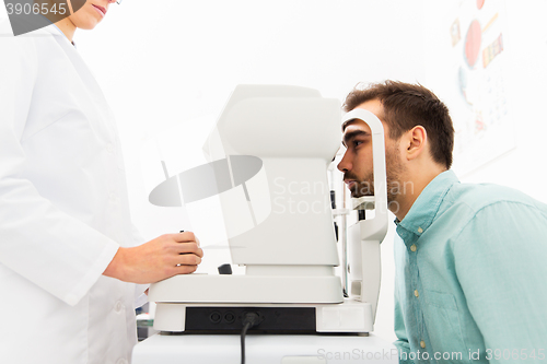 Image of optician with autorefractor and patient at clinic