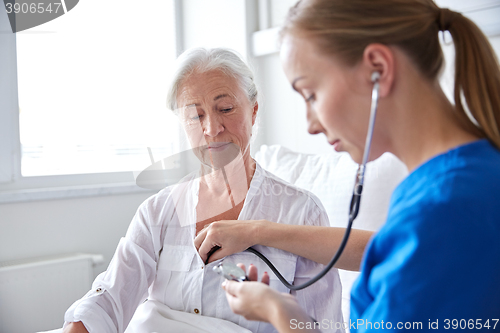 Image of nurse with stethoscope and senior woman at clinic