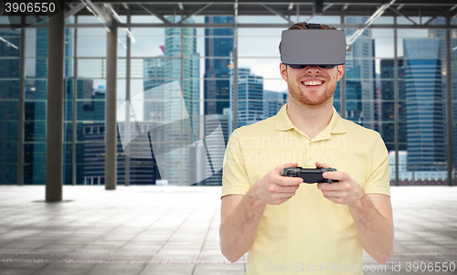Image of happy man in virtual reality headset with gamepad