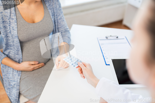 Image of close up of doctor giving pills to pregnant woman