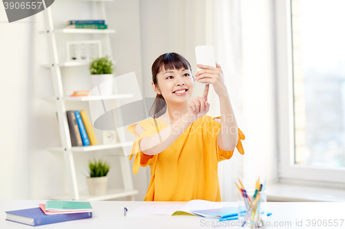 Image of asian woman student taking selfie with smartphone