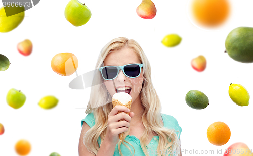 Image of happy young woman in sunglasses eating ice cream