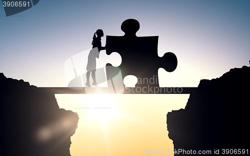 Image of silhouette of woman moving puzzle over sun light