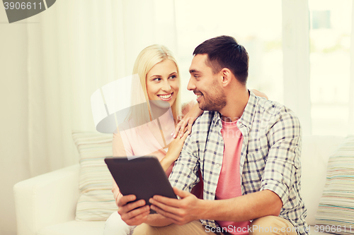 Image of smiling happy couple with tablet pc at home