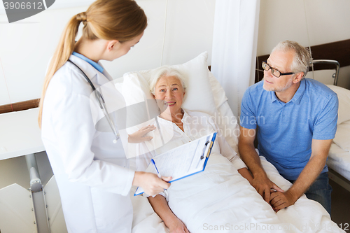 Image of senior woman and doctor with clipboard at hospital