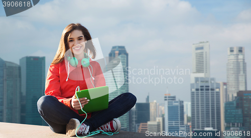 Image of happy young woman with tablet pc and headphones