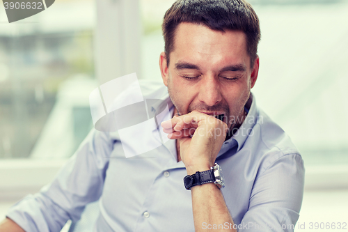 Image of yawning tired man at home or office