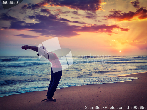 Image of Young sporty fit woman doing yoga Sun salutation Surya Namaskar