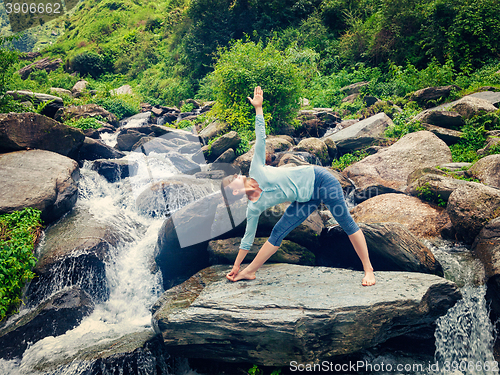 Image of Woman doing Ashtanga Vinyasa yoga asana Utthita trikonasana