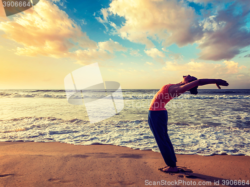 Image of Young sporty fit woman doing yoga Sun salutation Surya Namaskar 